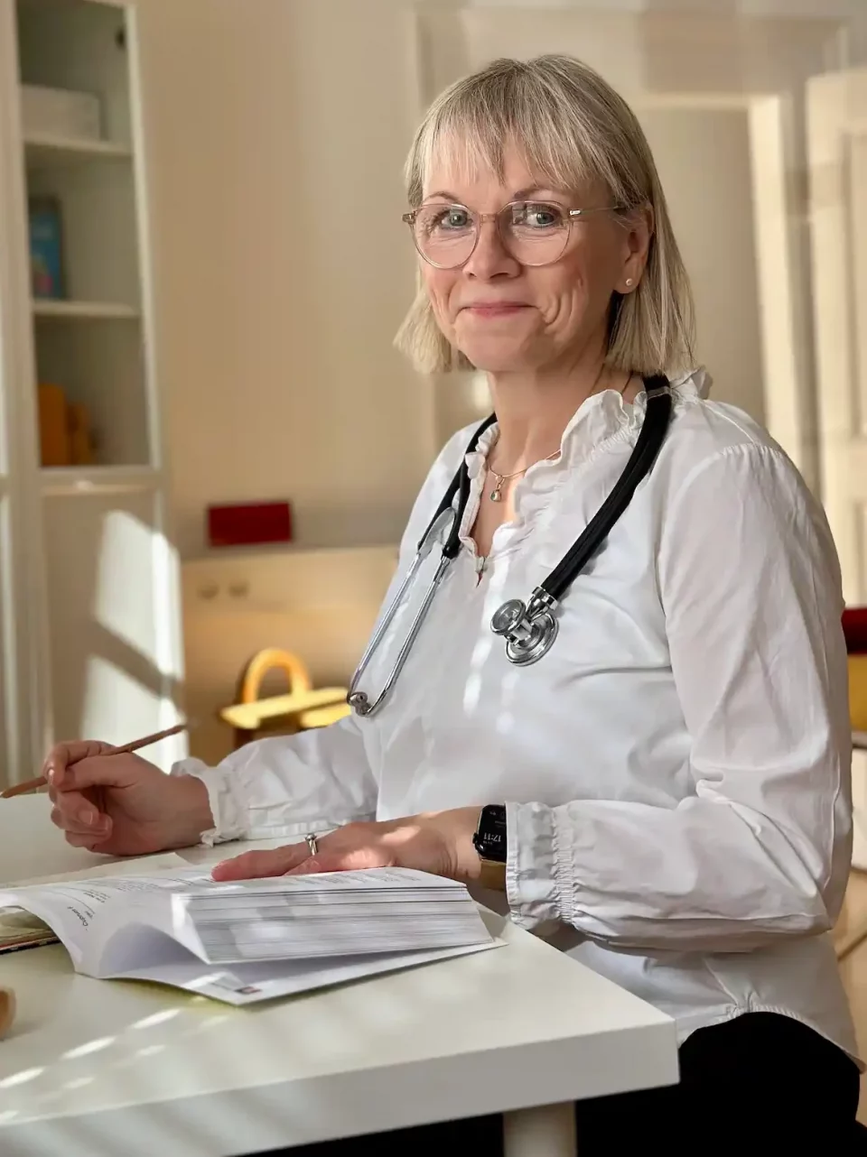 Blonde Katrin Zähle Heilpraktikerin sitzt vor Praxisunterlagen – ganzheitliche Naturheilkunde und persönliche Beratung im Dreiländereck.